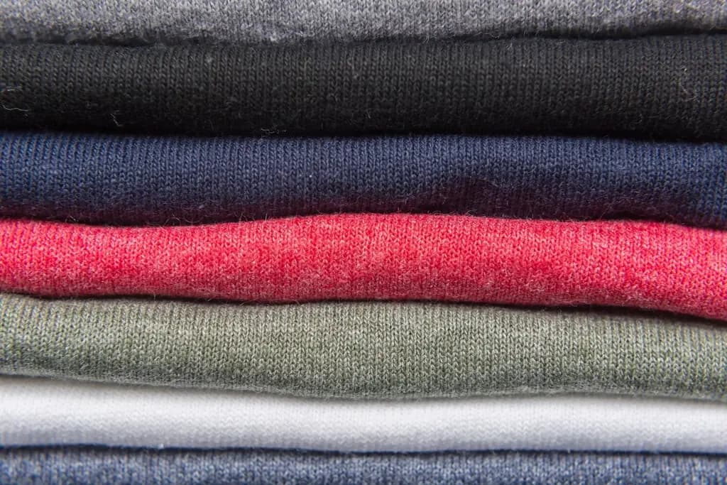 Stack of folded cotton T-shirts in assorted colours